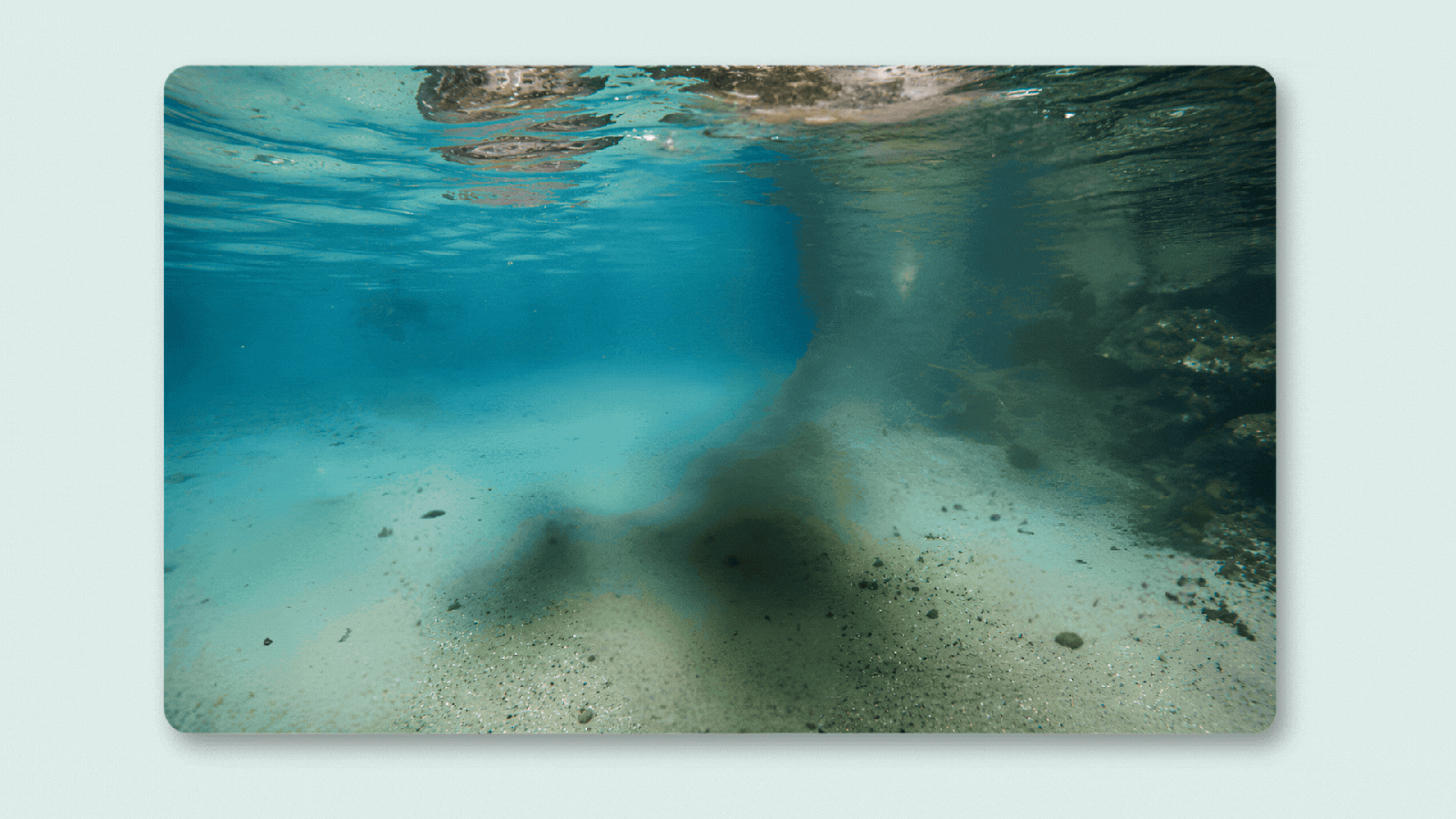 Underwater scene with clear blue water and sandy bottom